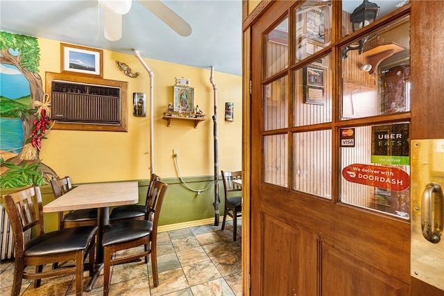 dining space with ceiling fan and a wall mounted air conditioner