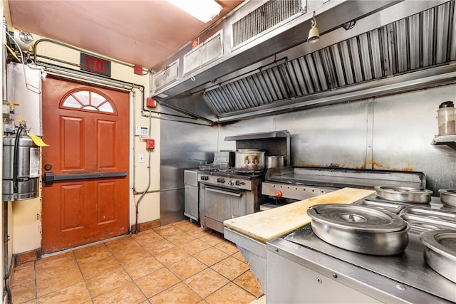 kitchen featuring light tile patterned flooring and high end stainless steel range oven