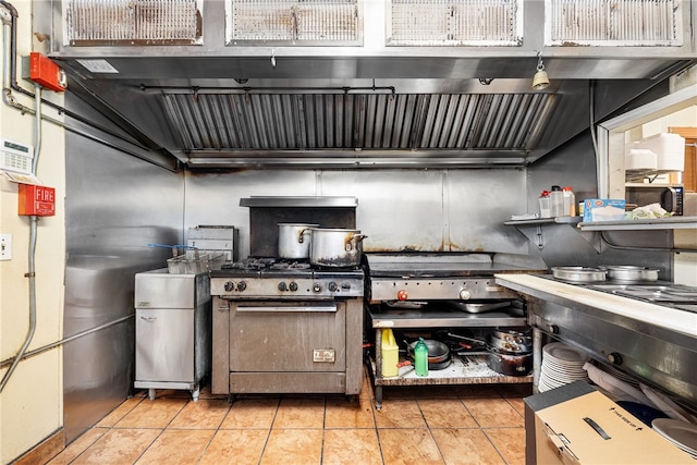 kitchen featuring light tile patterned floors and high end stainless steel range