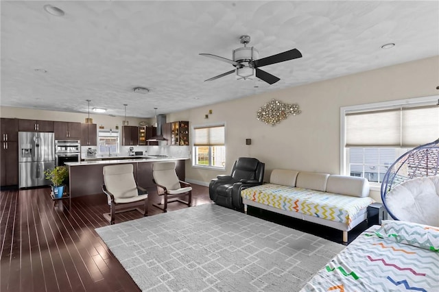 living room with ceiling fan and dark wood-type flooring