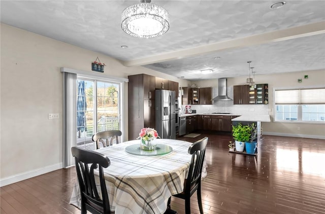 dining area with a notable chandelier and dark hardwood / wood-style flooring