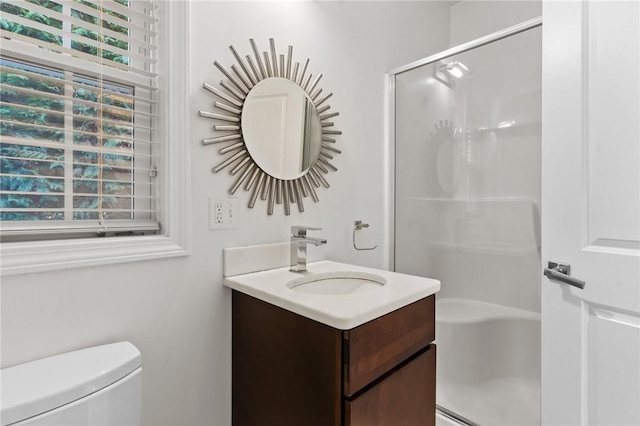 bathroom with vanity, a shower with shower door, and toilet