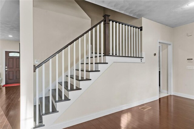 staircase with wood-type flooring