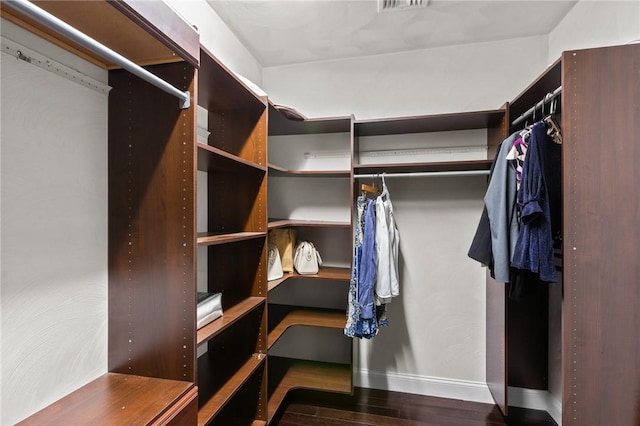 walk in closet with dark hardwood / wood-style floors