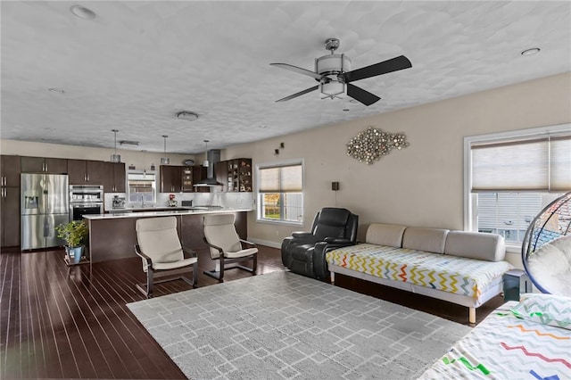 living room featuring a textured ceiling, dark hardwood / wood-style flooring, and ceiling fan