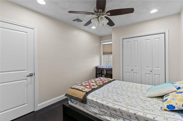 bedroom with ceiling fan, dark wood-type flooring, and a closet