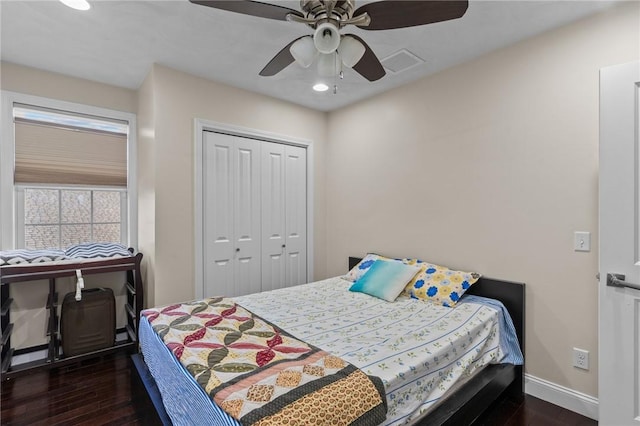 bedroom with dark hardwood / wood-style flooring, ceiling fan, and a closet