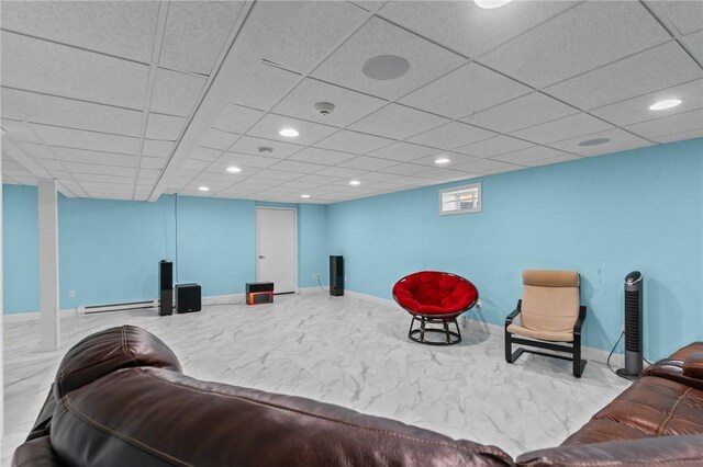 living area featuring a paneled ceiling and a baseboard heating unit