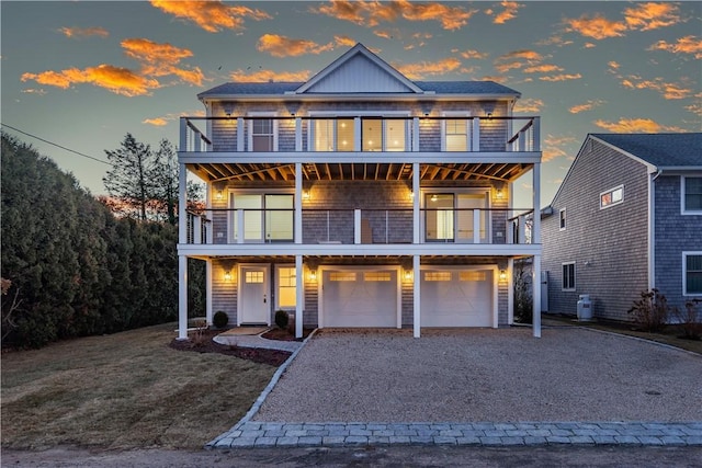 view of front of home with a yard, a balcony, and a garage