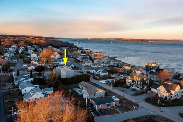 aerial view at dusk featuring a water view