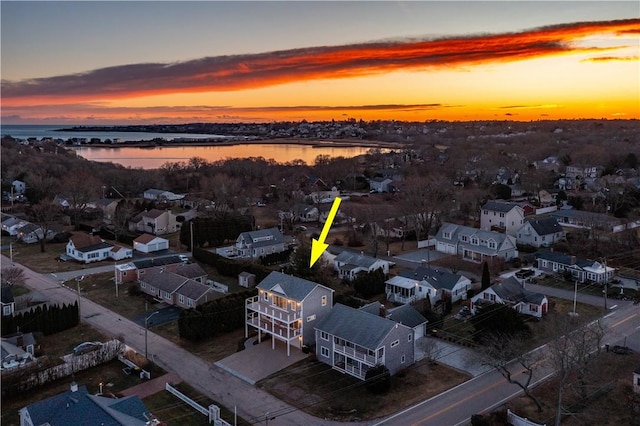 aerial view at dusk featuring a water view