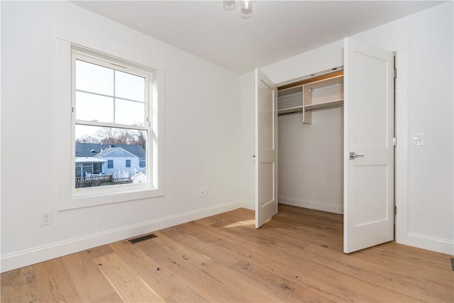 unfurnished bedroom with a closet and light hardwood / wood-style flooring