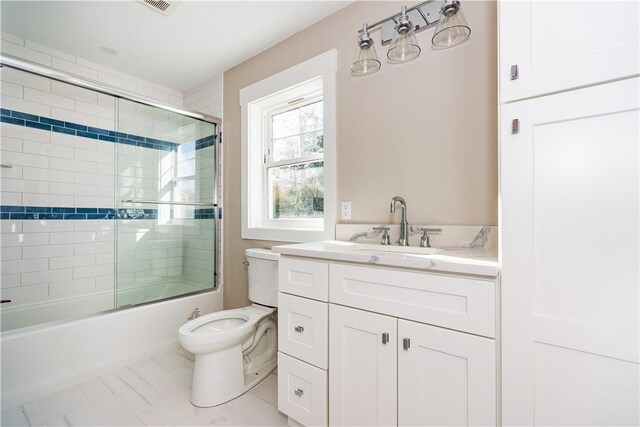 full bathroom with vanity, toilet, and bath / shower combo with glass door