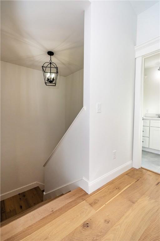 staircase featuring a chandelier and hardwood / wood-style flooring