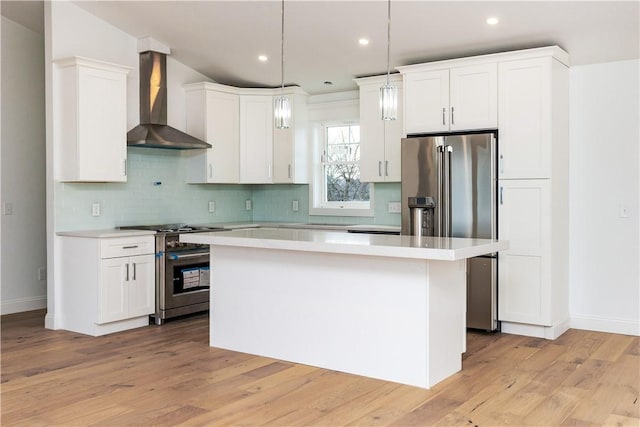 kitchen with white cabinets, wall chimney exhaust hood, a center island, and high quality appliances