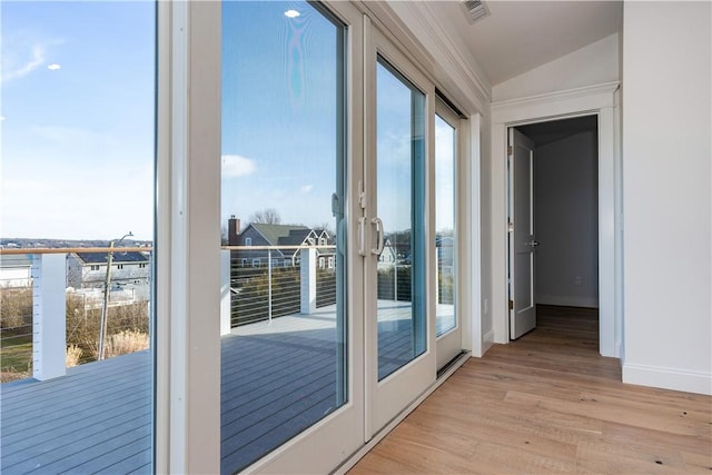 doorway featuring french doors, plenty of natural light, lofted ceiling, and light wood-type flooring