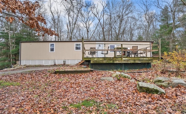 rear view of property featuring a wooden deck