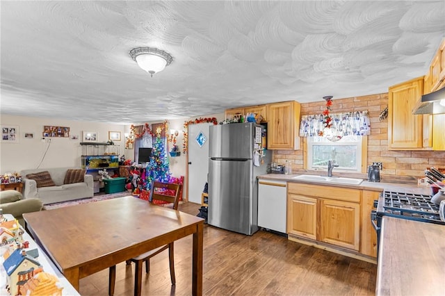 kitchen featuring sink, pendant lighting, wood-type flooring, dishwasher, and stainless steel refrigerator