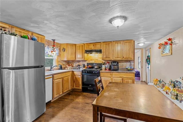 kitchen with stainless steel refrigerator, sink, hanging light fixtures, black range with gas cooktop, and white dishwasher