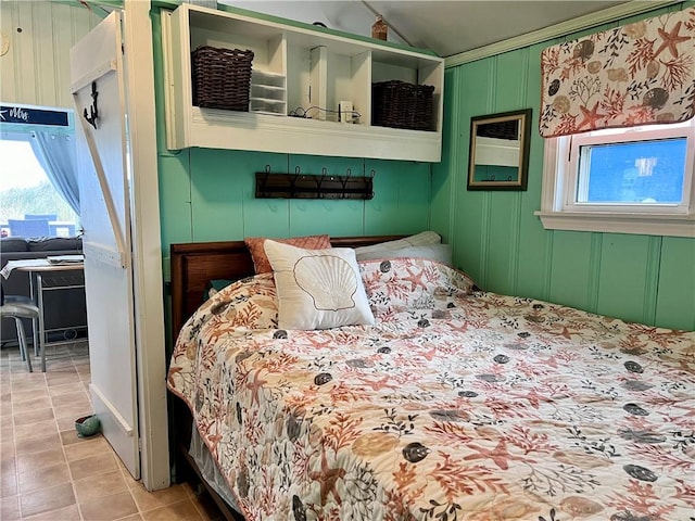 bedroom with vaulted ceiling and light tile patterned flooring