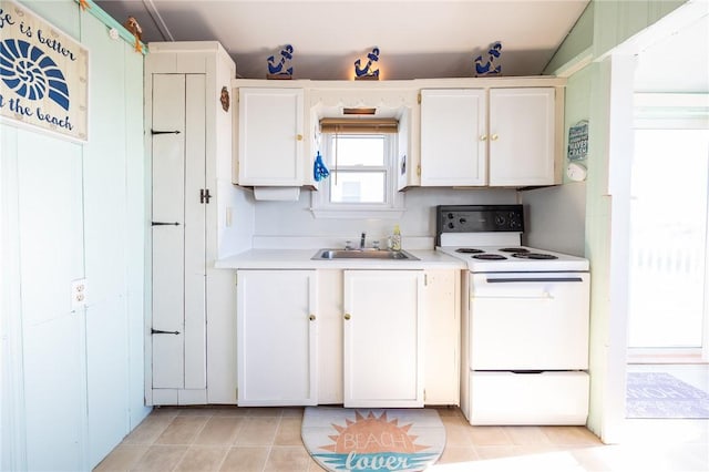 kitchen with white cabinets, white electric range oven, and sink