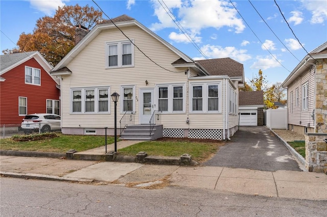 view of front of home featuring a front yard, a garage, and an outdoor structure