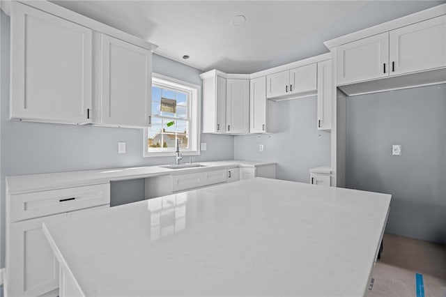 kitchen featuring white cabinetry, sink, and a kitchen island