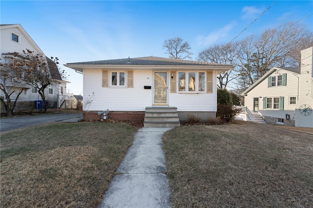 bungalow-style home with a front yard