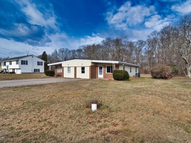 ranch-style home with a carport and a front lawn