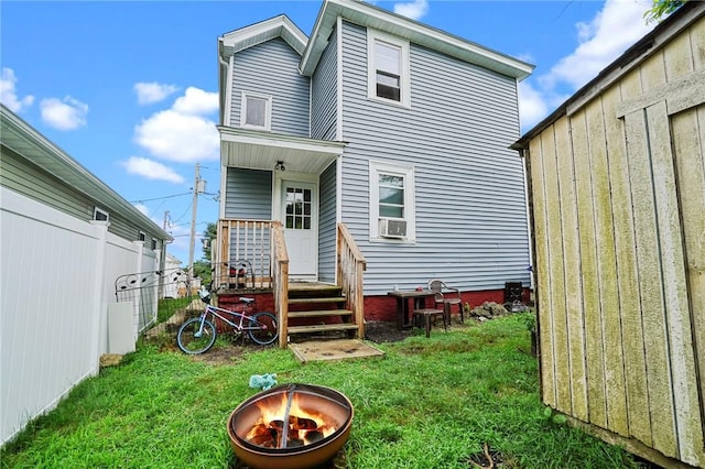 rear view of house featuring a yard and an outdoor fire pit