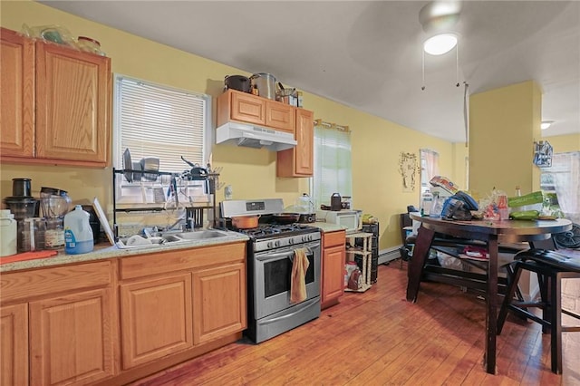 kitchen with gas range, light hardwood / wood-style floors, and a baseboard radiator