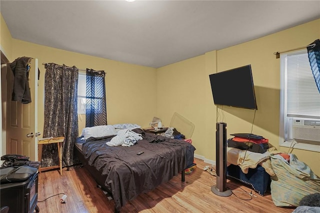 bedroom featuring hardwood / wood-style floors and cooling unit