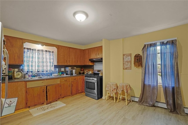 kitchen with gas stove, light hardwood / wood-style flooring, and sink