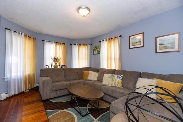 living room featuring baseboard heating, dark hardwood / wood-style floors, and a textured ceiling