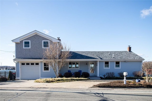 view of front of property featuring a chimney, a shingled roof, concrete driveway, fence, and a garage