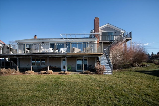 rear view of house with a deck, a yard, stairway, and a chimney