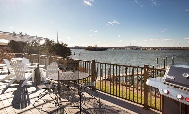 wooden deck featuring a water view, outdoor dining space, and area for grilling