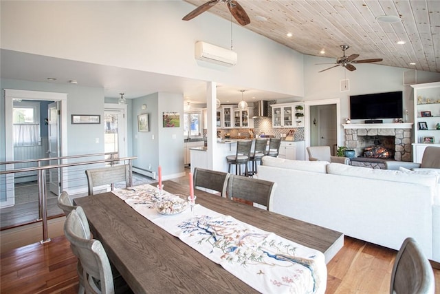 dining space featuring an AC wall unit, wooden ceiling, ceiling fan, and baseboard heating