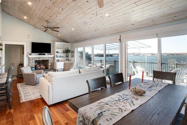 living room featuring ceiling fan, a stone fireplace, wooden ceiling, recessed lighting, and wood finished floors