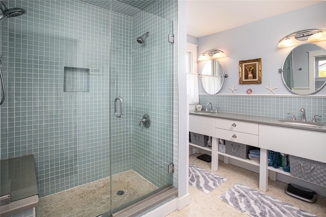 full bathroom with double vanity, a sink, and a shower stall