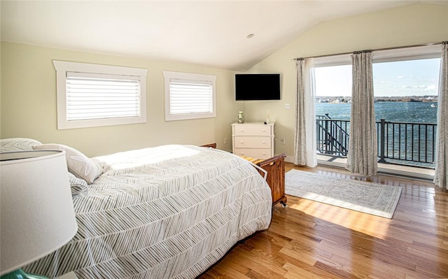 bedroom featuring lofted ceiling, access to outside, and wood finished floors