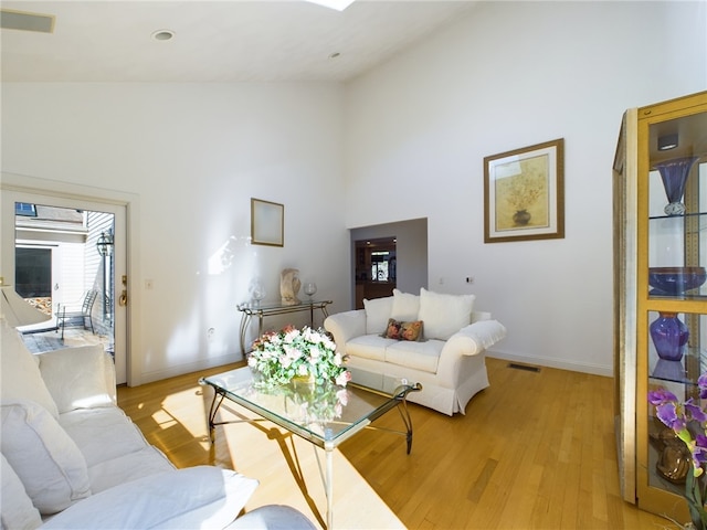 living room featuring light hardwood / wood-style flooring and a high ceiling