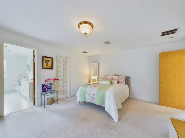 carpeted bedroom featuring a closet and ensuite bath