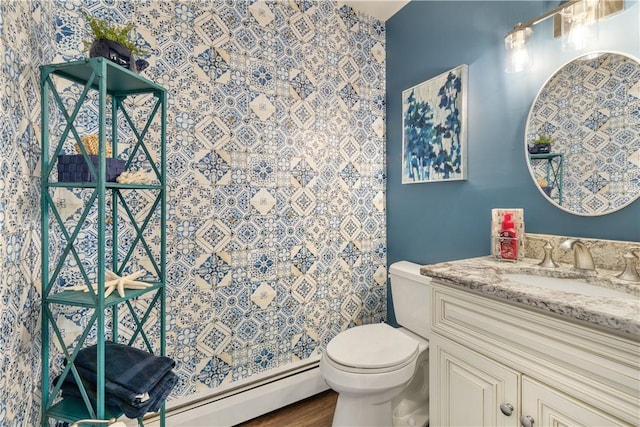 bathroom featuring baseboard heating, vanity, wood-type flooring, and toilet