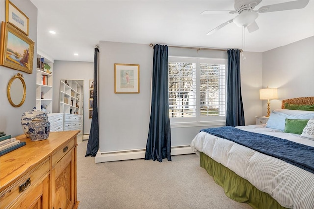 carpeted bedroom featuring ceiling fan and a baseboard heating unit