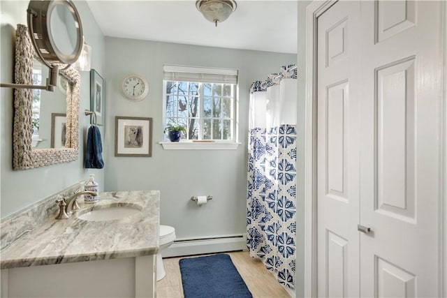 bathroom featuring vanity, toilet, and baseboard heating