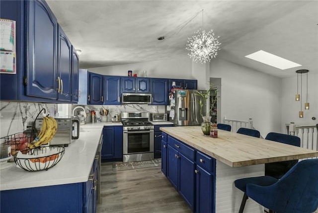 kitchen featuring tasteful backsplash, blue cabinets, and appliances with stainless steel finishes