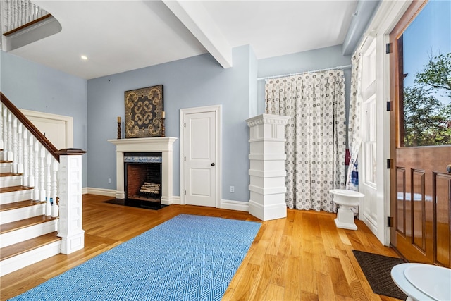 interior space featuring beamed ceiling and light hardwood / wood-style floors