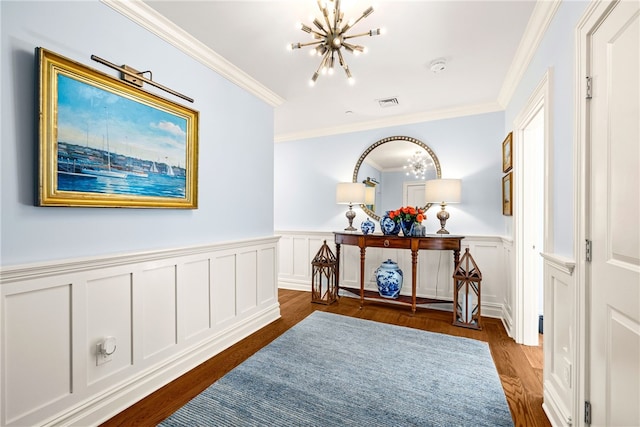 hall featuring dark hardwood / wood-style floors, an inviting chandelier, and crown molding