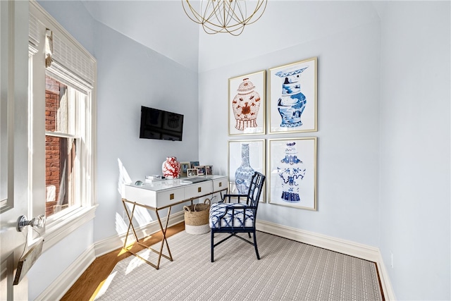 home office with vaulted ceiling, light hardwood / wood-style flooring, an inviting chandelier, and a wealth of natural light